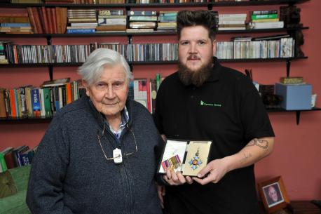 Clearance Service team member returning a CBE medal to a war hero during a house clearance in Worthing